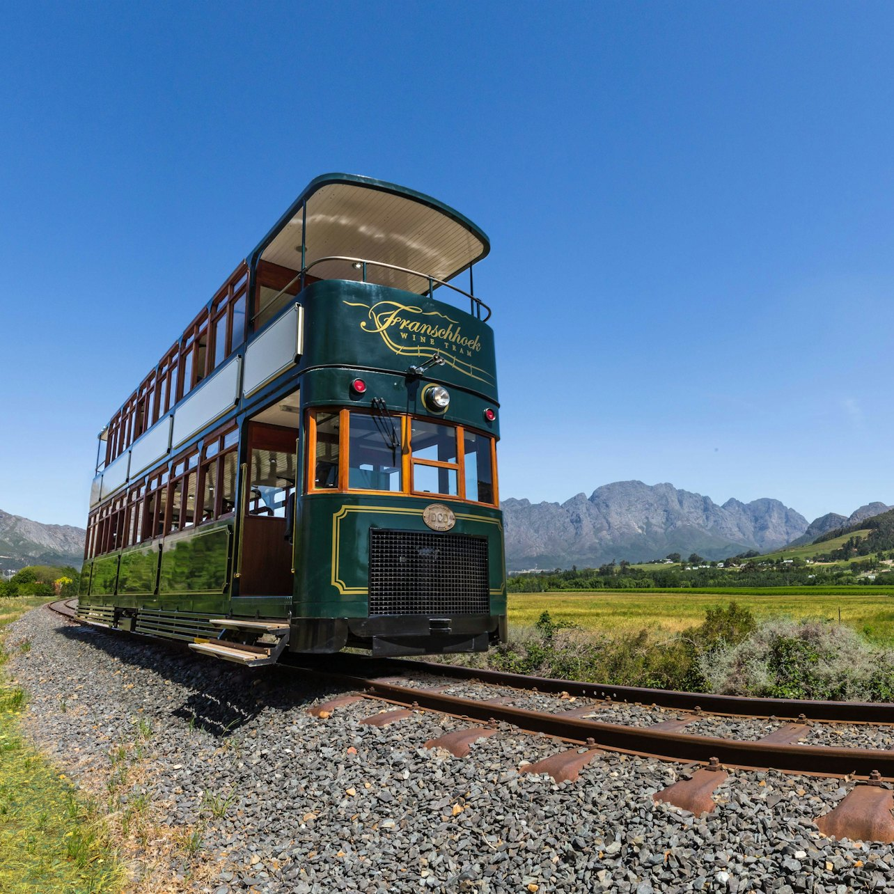 Experience the stunning landscapes of Franschhoek Wine Valley as the wine tram glides along the scenic tracks inviting you to explore acclaimed vineyards steeped in rich history.
